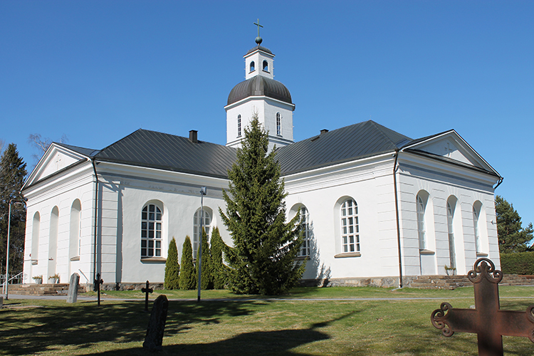 Valkoinen kivikirkko, jossa tummanharmaa peltikatto